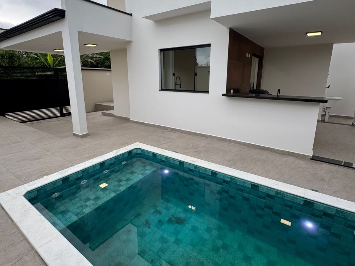 Área externa da Casa 2 com a piscina e a varanda gourmet ao lado.