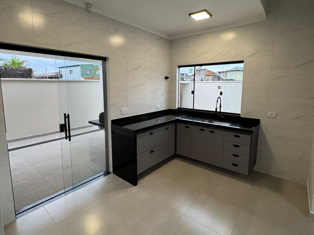 Cozinha da Casa 2 com bancada em L e armários planejados.